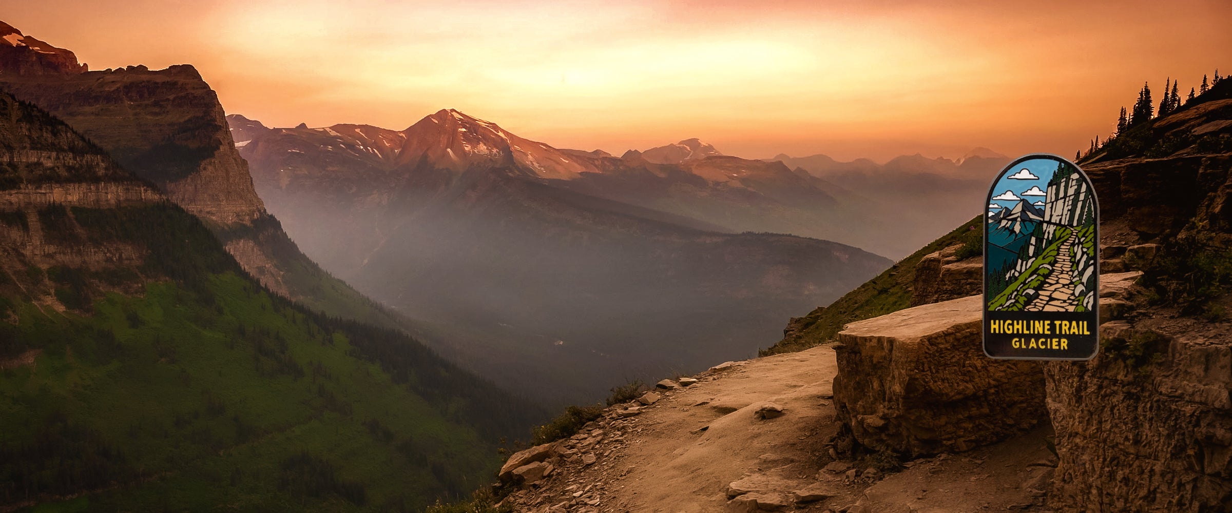Mountain landscape at sunset with layered peaks, a trail along the right foreground, and a trail sign reading Highline Trail Glacier. This is best classified as Scenery because the depicted landscape itself appears to be the subject/product rather than a product placed in an environment.